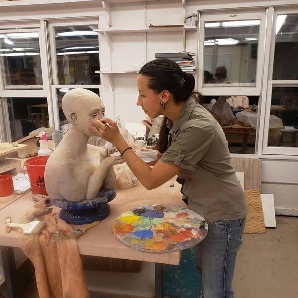 Olga Yukhno working with her sculpture