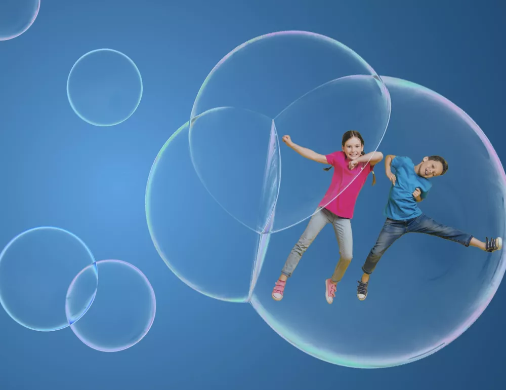 Stock photo of children in a bubble with a blue background. 